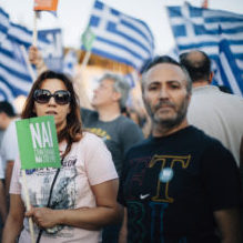 Athens, Greece - July 3, 2015: A woman holding a small flag during a protest in Panathinaikon Stadium (Kalimarmaro) in Athens, in favour of "NAI" or YES in the Greek Referendum voting.