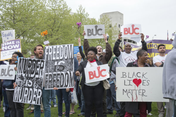 Baltimore, USA - May 1, 2015: Protestors at the War Memorial Plaza in front of City Hall. Recent unrest is the result of a pattern of white police violence against black men and the recent death of Freddie Gray.