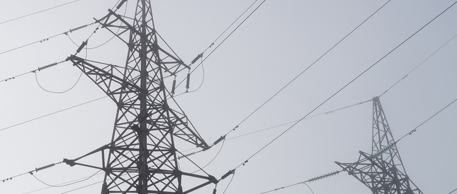 Electric high voltage power towers at morning mist