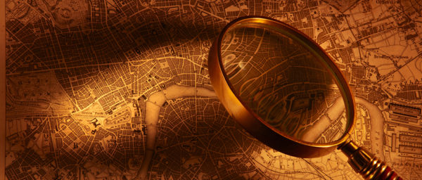 Antique map of London with magnifying glass casting light onto it