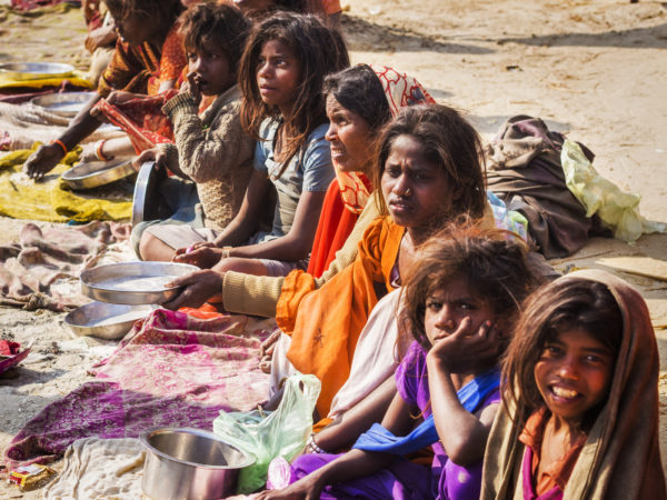 Allahabad, India - February 10, 2013: Poor Indian woman and children begging for food on the streets in Allahabad, Uttar Pradesh, India.